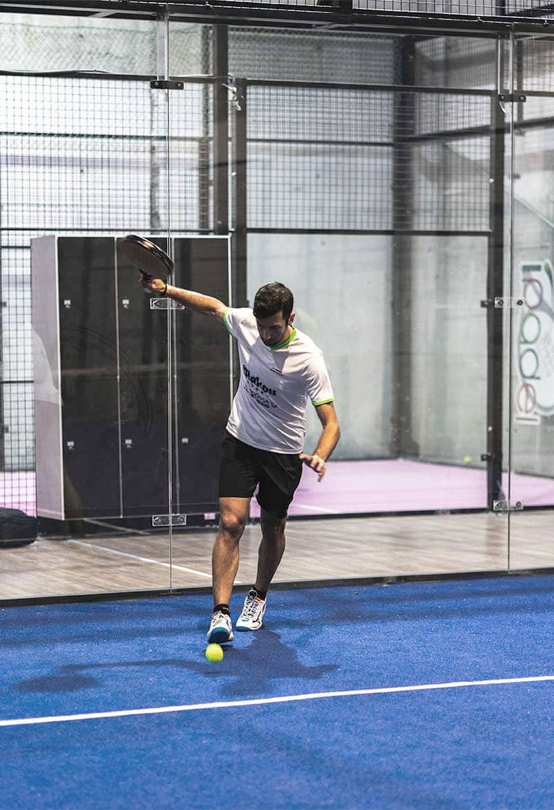 Jugador sacando al pádel en Pistas de Vigo